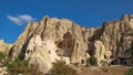 Foreign tourists visiting fabulous natural park with carved rock christian church from volcanic tuff formation.