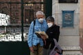 Foreign tourists wearing protective masks reading a brochure outside St Antuan Church