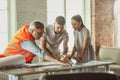 Foreman or achitect shows house, office or store design plans to a young couple