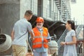 Foreman or achitect shows house, office or store design plans to a young couple