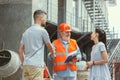 Foreman or achitect shows house, office or store design plans to a young couple