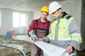 Foreman builder and construction worker with blueprint in indoor apartment Royalty Free Stock Photo