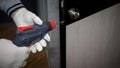 The foreman carries out repair work in the apartment  drills the door lock  the man repairs the interior door. Royalty Free Stock Photo