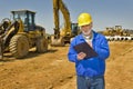 Foreman With Clipboard and Highway Construction Equipment