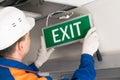 Foreman completes installation  of lighting signs emergency exit Royalty Free Stock Photo