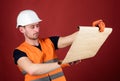 Foreman concept. Engineer, architect, builder on strict face holds blueprint in hands, supervises construction site Royalty Free Stock Photo