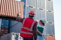 Foreman control loading Containers box from Cargo freight ship for import export. Royalty Free Stock Photo