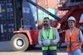 Foreman control loading Containers box from Cargo freight ship for import export. Royalty Free Stock Photo