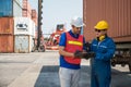 Foreman and dock worker staff working checking at Container cargo harbor holding clipboard. Business Logistics import export