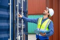 Foreman or Engineer wears white helmet and reflection shirt to control or check inventory details of containers box. Container Royalty Free Stock Photo