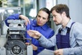 Foreman explaining working motor to female trainee