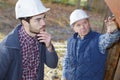 foreman giving junior worker instructions outdoors Royalty Free Stock Photo