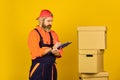 Foreman planning. unpacking moving boxes. new house at moving day. bearded man builder in boilersuit hold boxes. moving Royalty Free Stock Photo