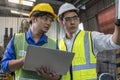 Foreman or Professional technician holding a laptop computer in an industrial factory. Male engineer apprentice trainee with
