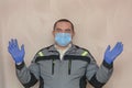 Foreman repairman in medical mask and gloves prepared for job. Man observes safety rules during covid-19 pandemic