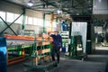 Foreman in a safety helmet stands at a loading trolley