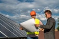 Foreman showing photovoltaic detail businessman at solar energy station