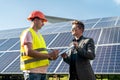 Foreman showing photovoltaic detail businessman at solar energy station