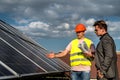 Foreman showing photovoltaic detail businessman at solar energy station