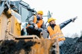 Foreman showing worker in open-cast mining pit direction