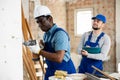 Foreman tells the builder where to drill holes with hammer drill Royalty Free Stock Photo