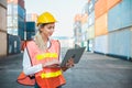 Foreman woman worker working checking at Container cargo harbor holding laptop computer to loading containers. Dock female staff Royalty Free Stock Photo