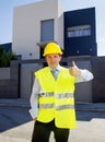 Foreman worker standing in front of new building project outdoors wearing construction helmet Royalty Free Stock Photo