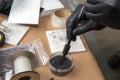 Forensic hand in glove brushing latent fingerprints evidence by