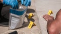 forensic inspector collecting firearm shells at a crime scene with a dead male person lying on the ground