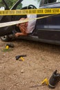 Forensic investigations in progress with scientific evidence signs and yellow police tape at a fake corpse of a woman behind the w Royalty Free Stock Photo