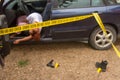 Forensic investigations in progress with scientific evidence signs and yellow police tape at a fake corpse of a woman behind the w Royalty Free Stock Photo