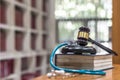 Forensic medicine investigation or malpractice justice concept with judge gavel and medical stethoscope on law textbook in library