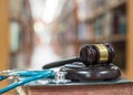 Forensic medicine investigation or malpractice justice concept with judge gavel and medical stethoscope on law textbook in library