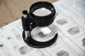 forensic scientist examines fingerprints with a magnifying glass in a laboratory.