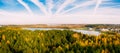 Forest with autumn trees in Minsk sea above. Yellow, red and green nature, high top view. Aerial drone shoot with wonderful blue s