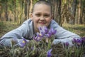 In the forest  boy lies on the ground and hugs the flowers to pasque-flower Royalty Free Stock Photo