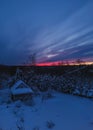 Forest cabin and trees in winter sunset. Wooden hut in the snow. forest on the evening sky background Royalty Free Stock Photo