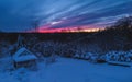 Forest cabin and trees in winter sunset. Wooden hut in the snow. forest on the evening sky background Royalty Free Stock Photo