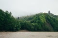 Forest covered with a fog early in the morning on the bank of the river. Carpathian Mountains, Ukraine, Europe