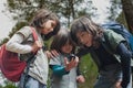 Forest Exploration: Three Children Using a Compass to Navigate and Find Their Way