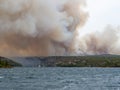 Forest fire in Croatia, summer natural disaster close to national park Krka, Sibenik region, boats and yachts escaping Skradin to