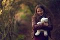In the forest with her fluffiest friend. Portrait of a young girl standing in the forest with her teddy bear. Royalty Free Stock Photo