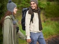 Forest, hiking and happy couple for holding hands, mountain and travel with backpack, nature and bonding. Outdoor Royalty Free Stock Photo