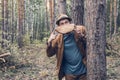 The forest inspection inspector jokingly holds in front of him a segment of a sawn tree