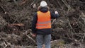 Forest inspector filmed near to pile sawed bushes and strains