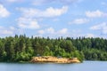 Forest lake with clear water and the island on which rest the tourists and travelers, natural landscape blue sky