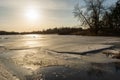 Forest lake with melting floating ice. Wildlife spring landscape with sunset