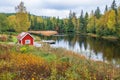 Forest lake with a red cottage by a bathing place Royalty Free Stock Photo