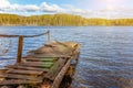 Forest lake or river on summer day and old rustic wooden dock or pier Royalty Free Stock Photo