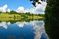Beautiful forest landscape. White clouds are reflected in the forest lake. Royalty Free Stock Photo